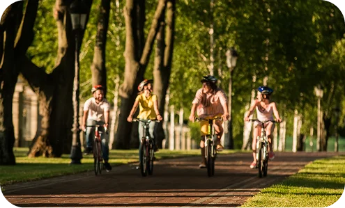 grupo de ciclistas pedaleando en el parque con arboles