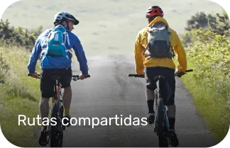 dos ciclistas hablando en la ruta mientras pedalean